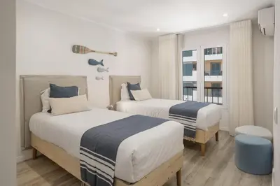two beds in a room with white and blue at Promenade II by An Island Apart in Funchal