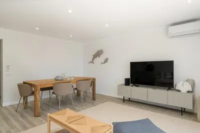 a living room with a dining table and a television at Promenade II by An Island Apart in Funchal