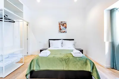 a bedroom with a bed with a green blanket at Casa Ribeiro in Funchal