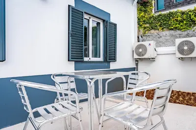 a table and chairs on a patio with a window at Casa Ribeiro in Funchal