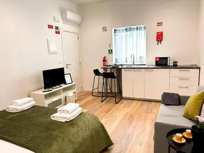 a living room with a couch and a kitchen at Casa Ribeiro in Funchal