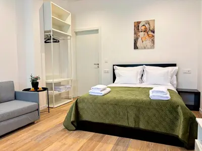 a bedroom with a bed with a chair and a couch at Casa Ribeiro in Funchal