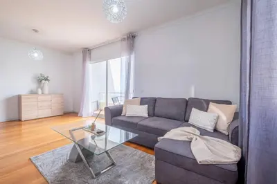 a living room with a couch and a glass table at Atlantic View I By GALMI in Santa Cruz