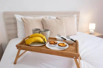 a tray with a banana and muffins on a bed at Atlantic View I By GALMI in Santa Cruz