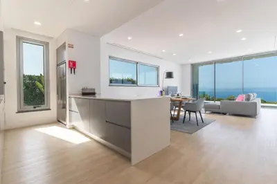 an open kitchen and living room with large windows at Villa Alegria by Atlantic Holiday in Calheta