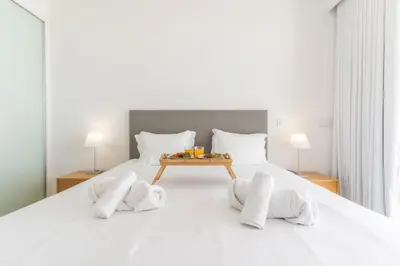 a bedroom with a bed with a tray of food on it at Villa Alegria by Atlantic Holiday in Calheta