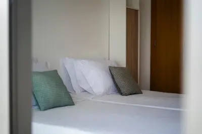 a white bed with two pillows on top of it at Casa da Baía Overlooking Funchal Bay in Funchal