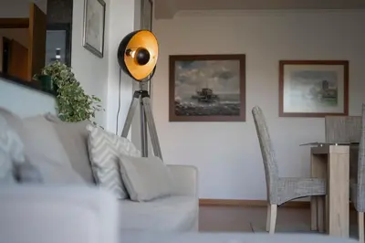 a living room with a white couch and a lamp at Casa da Baía Overlooking Funchal Bay in Funchal