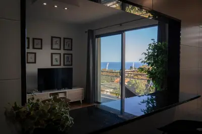 a living room with a large window with a view of the ocean at Casa da Baía Overlooking Funchal Bay in Funchal