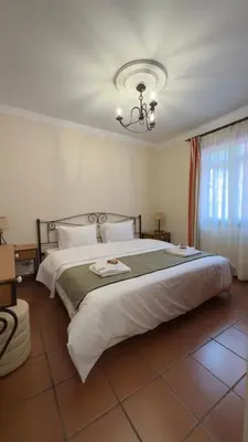 a bedroom with a large white bed with a chandelier at Vila Rocha Do Sol 59A - Ensuite Room With Balcony View in Canhas