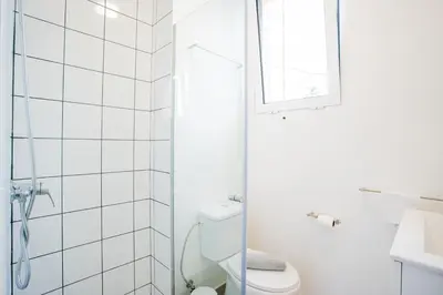 a white bathroom with a toilet and a window at Madeira Melody in Funchal