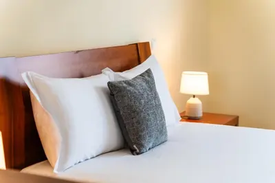 a bedroom with a bed with white pillows and a lamp at GuestReady – Charming Getaway by Madeira's Nature in Santana