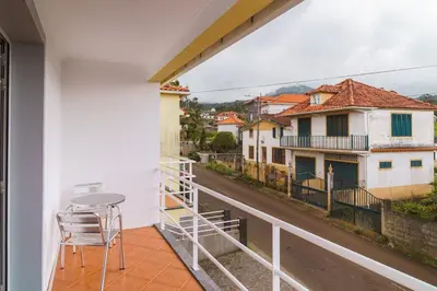 a balcony with a table and chairs overlooking a street at GuestReady – Charming Getaway by Madeira's Nature in Santana