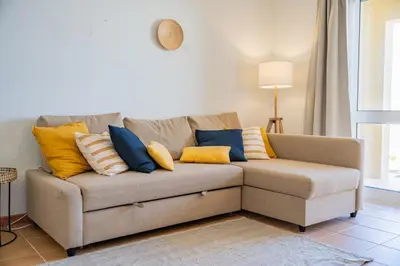 a couch with colorful pillows on it in a living room at Ohana - Casa de Praia by YOUR KEY in Porto Santo