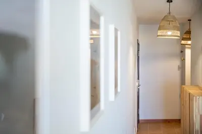 a hallway with two pendant lights and a white wall at Ohana - Casa de Praia by YOUR KEY in Porto Santo