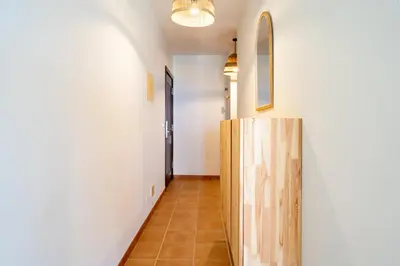 a hallway with white walls and a wooden door at Ohana - Casa de Praia by YOUR KEY in Porto Santo