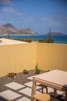 a patio with a table and a view of the beach at Ohana - Casa de Praia by YOUR KEY in Porto Santo