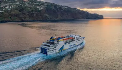 a ferry boat in the water near a mountain at Ohana - Casa de Praia by YOUR KEY in Porto Santo