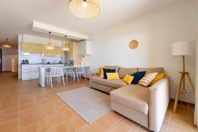 a living room with a couch and a kitchen at Ohana - Casa de Praia by YOUR KEY in Porto Santo
