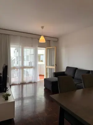 a living room with a couch and a table at Ohana Funchal in Funchal