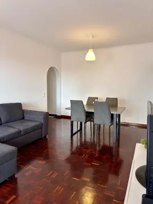 a living room with a couch and a table and chairs at Ohana Funchal in Funchal