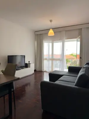 a living room with a couch and a tv at Ohana Funchal in Funchal