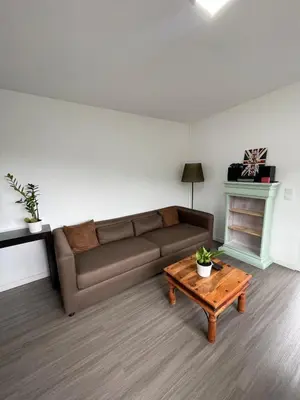 a living room with a table and a kitchen with a tv at Charming hill view retreat in Funchal
