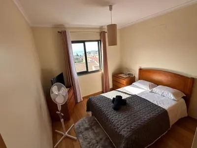a bedroom with a bed and a fan and a window at Heart of Madeira in Funchal