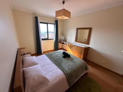 a bedroom with a bed and a dresser and a mirror at Heart of Madeira in Funchal