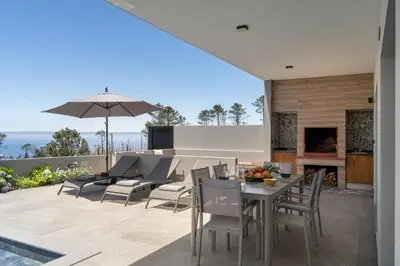 a patio with a table and chairs and a fireplace at Vila da Ponta do Pargo by An Island Apart in Ponta do Pargo