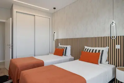 two beds with orange pillows in a hotel room at Vila da Ponta do Pargo by An Island Apart in Ponta do Pargo