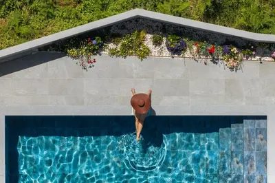 a person with a hat in a swimming pool at Vila da Ponta do Pargo by An Island Apart in Ponta do Pargo