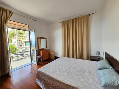 a bedroom with a bed and a sliding glass door at Villa Rodrigues 1 by Rentallido in Campanário