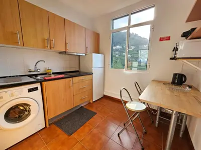 a kitchen with a washing machine and a table at Villa Rodrigues 1 by Rentallido in Campanário