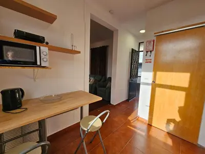 a kitchen with a table and chairs and a microwave at Villa Rodrigues 1 by Rentallido in Campanário