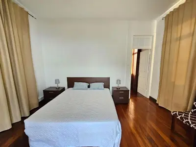 a bedroom with a large bed and two night stands at Villa Rodrigues 1 by Rentallido in Campanário