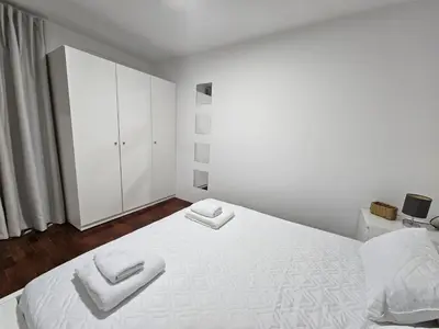 a white bedroom with a large bed with two white towels at Villa Rodrigues 2 by Rentallido in Campanário