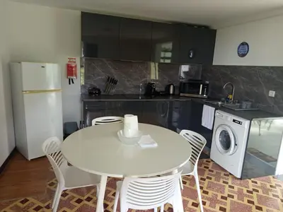 a kitchen with a white table and white appliances at Villa Rodrigues 2 by Rentallido in Campanário
