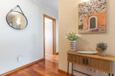 a hallway with a mirror and a table with flowers on it at Senhora do Pilar by Atlantic Holiday in Santo António