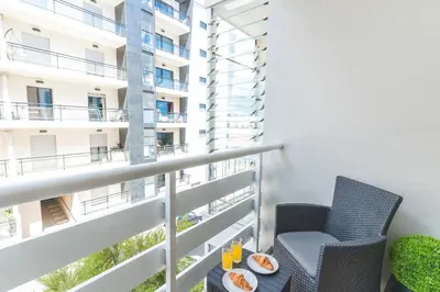 a balcony with two chairs and a table with food on it at Senhora do Pilar by Atlantic Holiday in Santo António