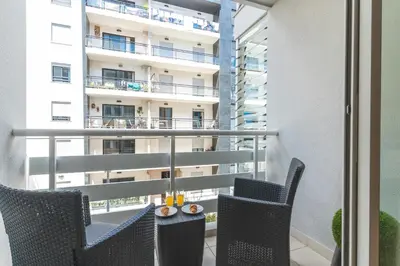 a balcony with two chairs and a table and a building at Senhora do Pilar by Atlantic Holiday in Santo António