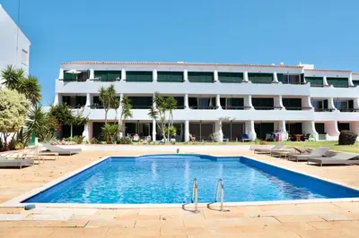 a swimming pool in front of a building at Apartamento Malino in Sagres
