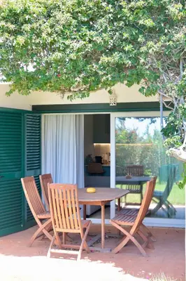 a wooden table and chairs on a patio at Apartamento Malino in Sagres