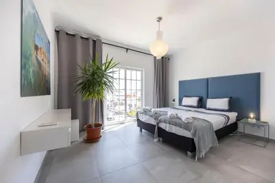 a bedroom with a large bed and a large window at Casa da Praça - Vila do Bispo, Algarve in Vila do Bispo