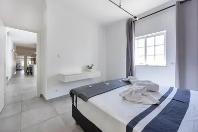 a bedroom with a bed and a large window at Casa da Praça - Vila do Bispo, Algarve in Vila do Bispo