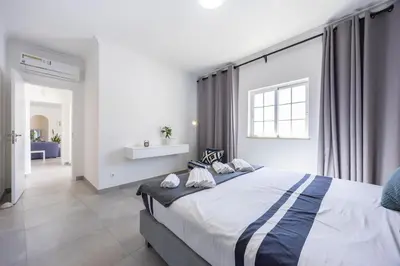 a bedroom with a large bed and a window at Casa da Praça - Vila do Bispo, Algarve in Vila do Bispo