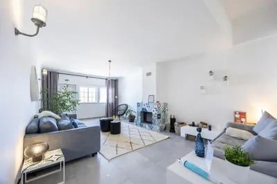 a living room with a couch and a fireplace at Casa da Praça - Vila do Bispo, Algarve in Vila do Bispo