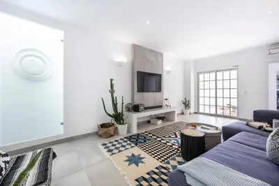 a living room with a couch and a tv at Casa da Praça - Vila do Bispo, Algarve in Vila do Bispo