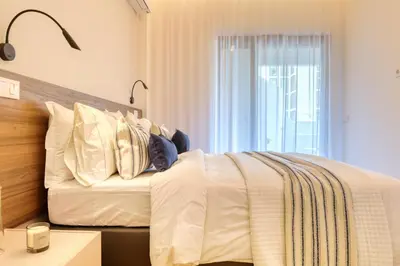 a bedroom with a bed with white sheets and a window at Funchal Acqua Blue 3O, a Home in Madeira in Funchal