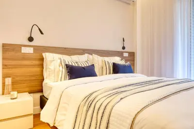 a bedroom with a large bed with a wooden headboard at Funchal Acqua Blue 3O, a Home in Madeira in Funchal